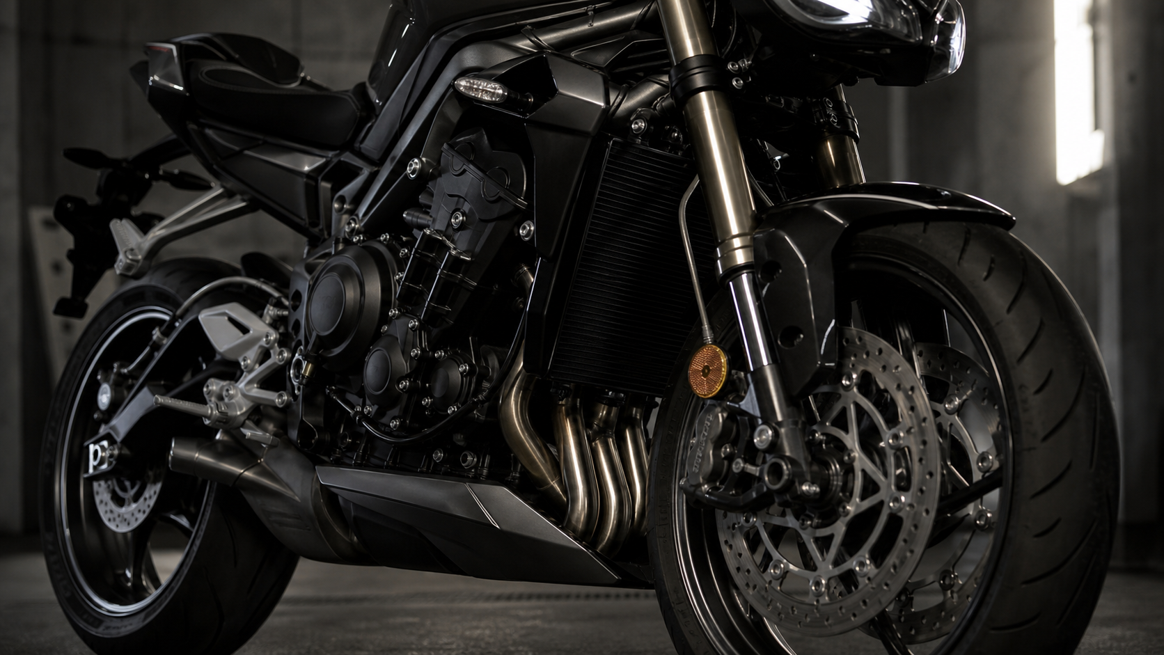 Triumph Street Triple 765 RS 765cc triple engine Brembo Stylema radial brake Ohlins STX40 and TFT detail in an industrial inspection bay